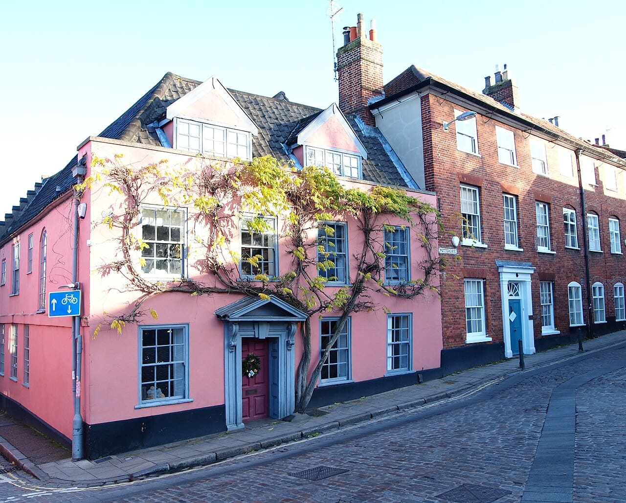 Pink and brick houses along a cobbled bend of Pottergate in the Norwich Lanes